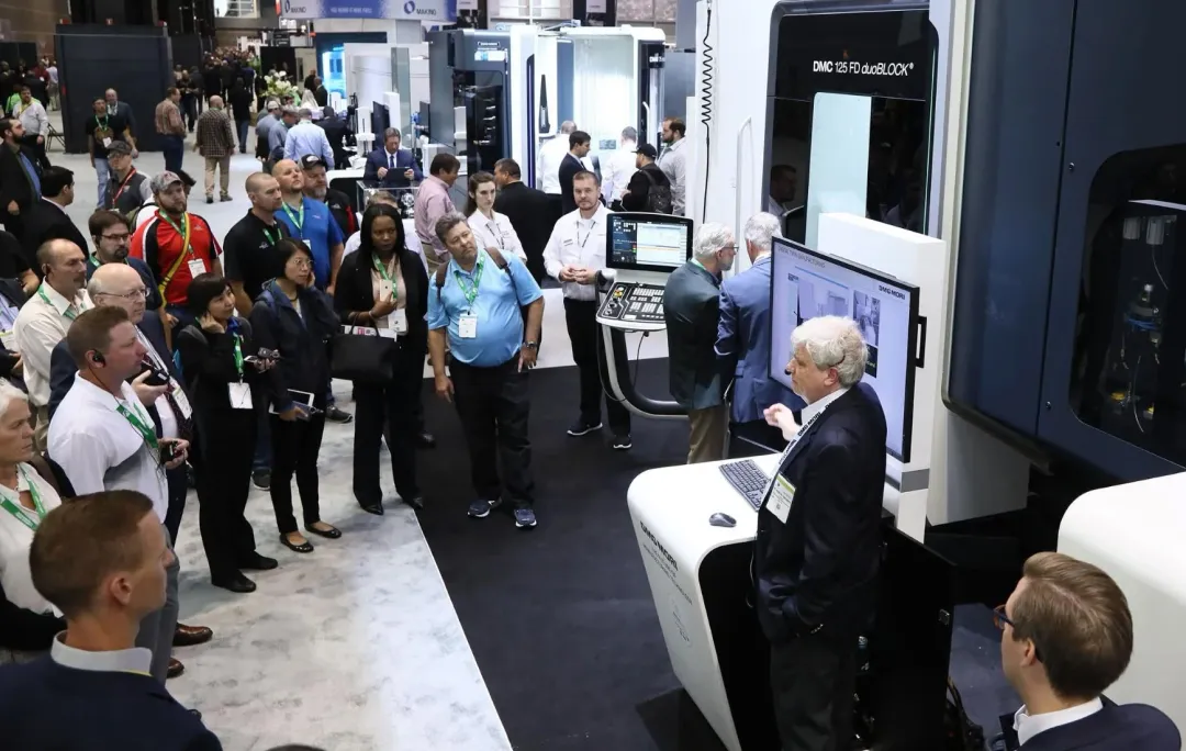 Visitors gathered around a presenter at a trade show booth