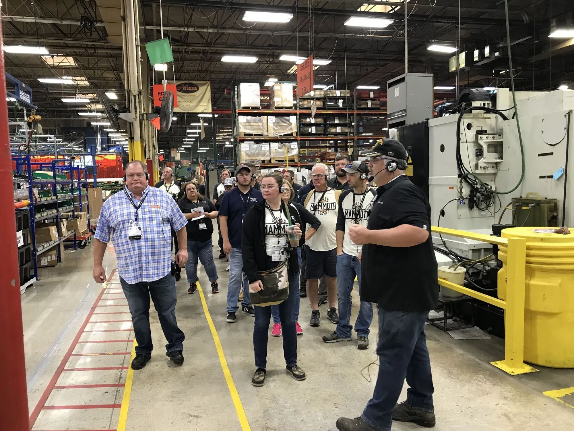 Tour group wearing headsets walking through a plant