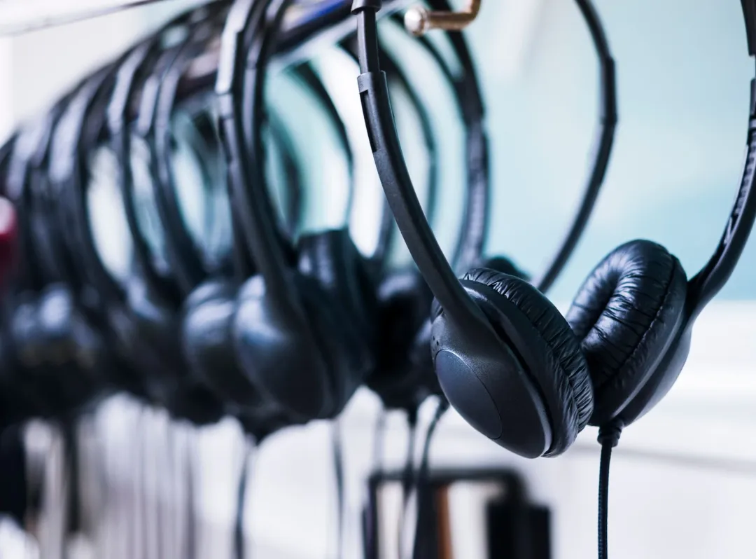 Row of tour guide headphones hanging on a rack