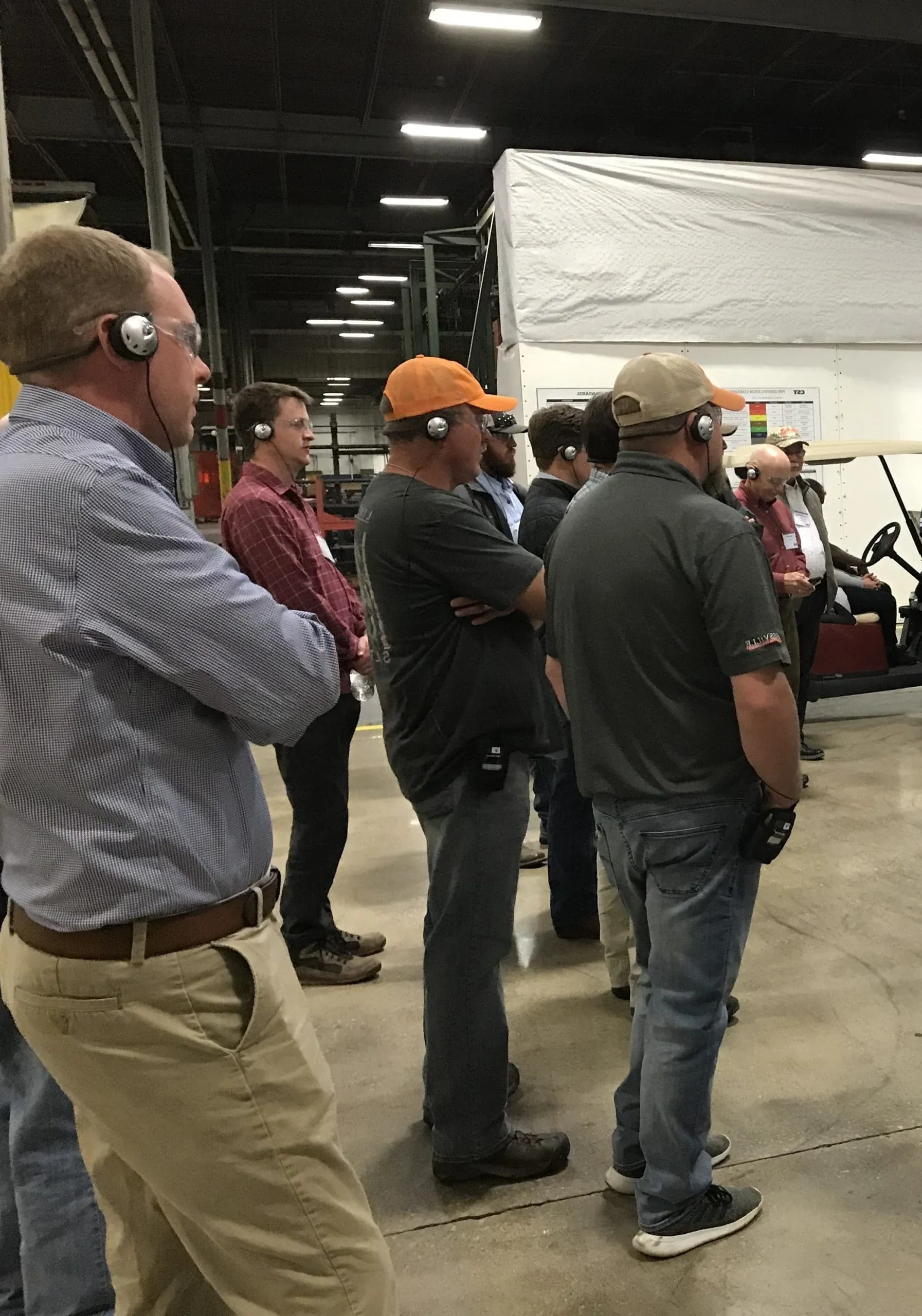 Visitors wearing headsets on a factory tour