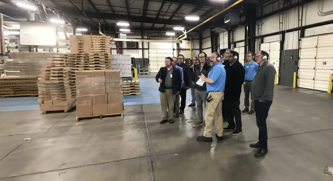 Tour group wearing Plant-Tours.com headsets in a warehouse