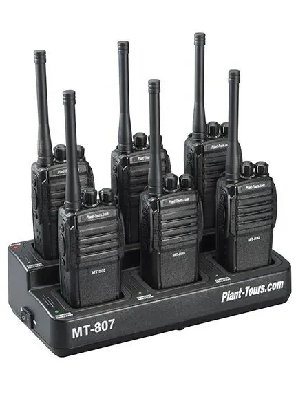 Six black two-way radios standing in a Plant-Tours.com multi-unit charging base labeled MT-807