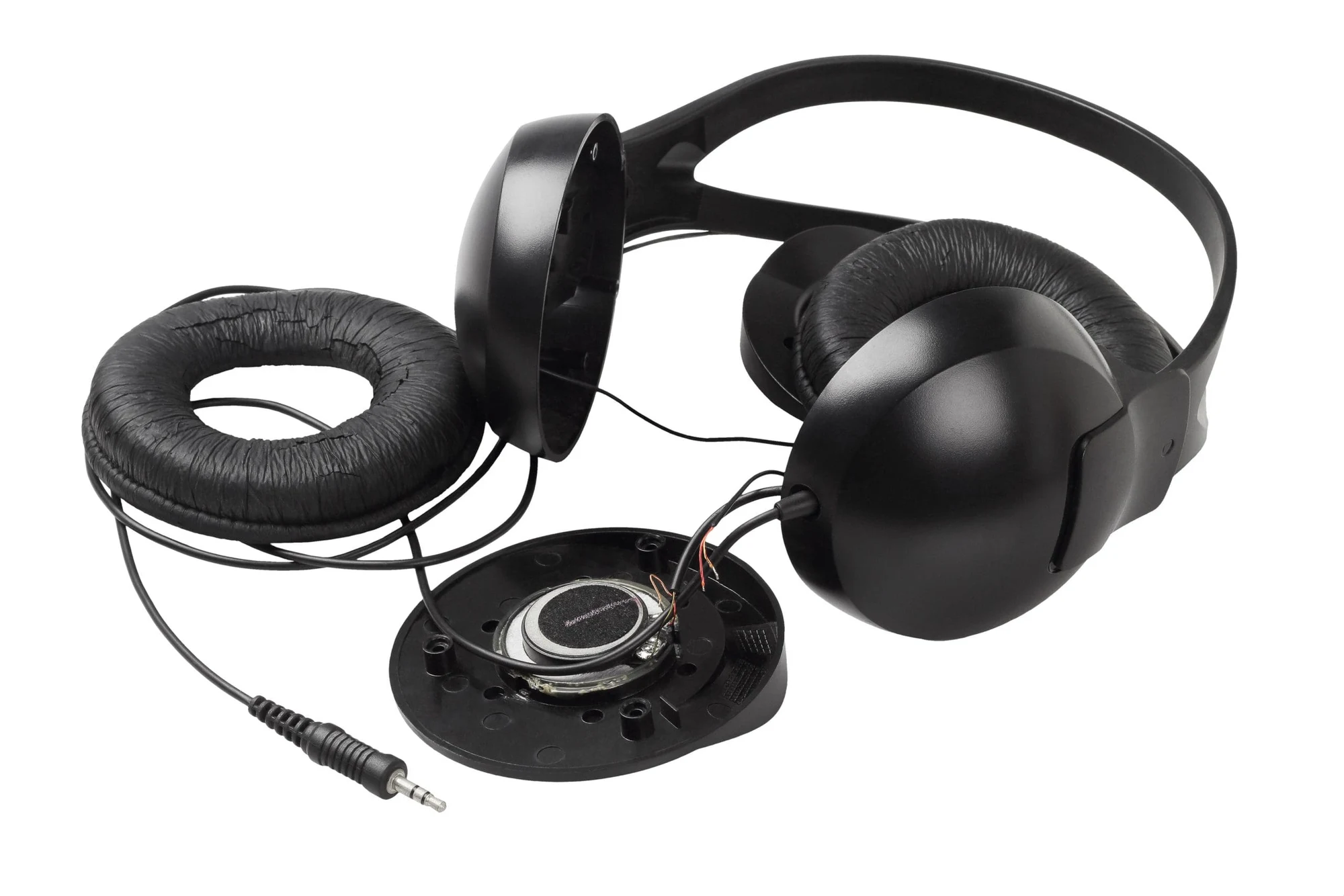 Disassembled black headset with ear cushion removed, showing the speaker inside the ear cup