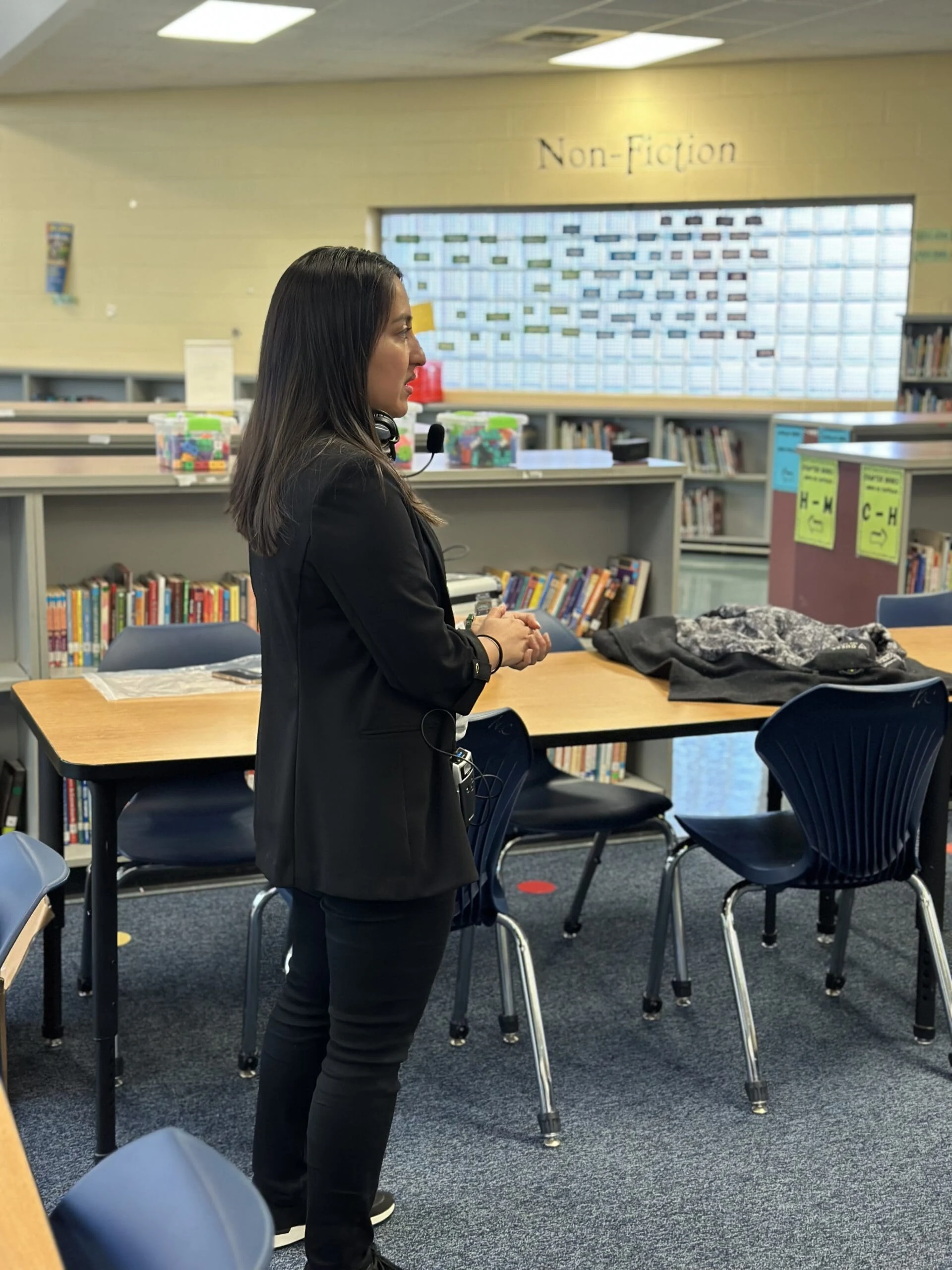 Woman presenting to a classroom while wearing a headset microphone